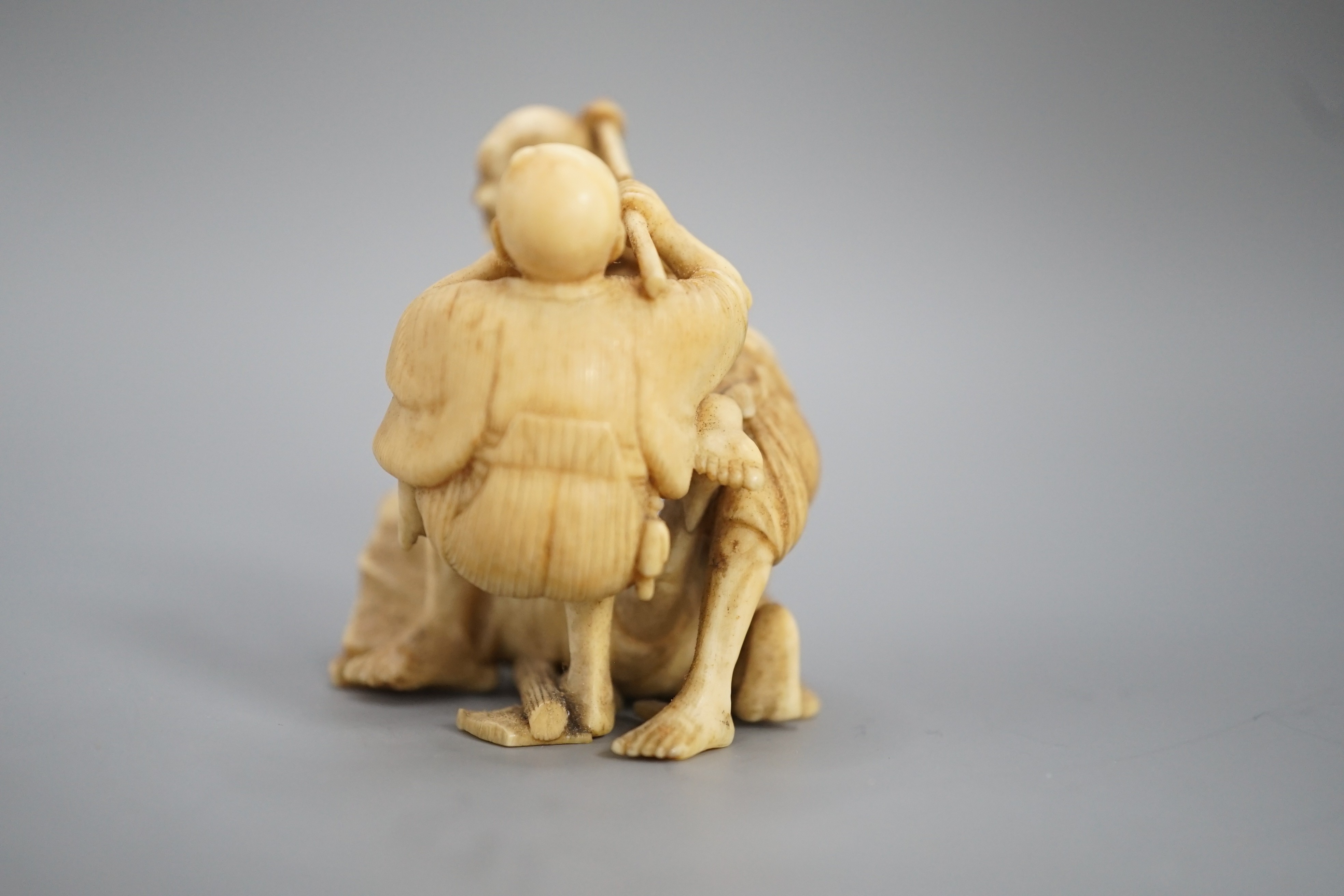 A Japanese ivory group of four men fighting, signed, Meiji period, 5.5cm